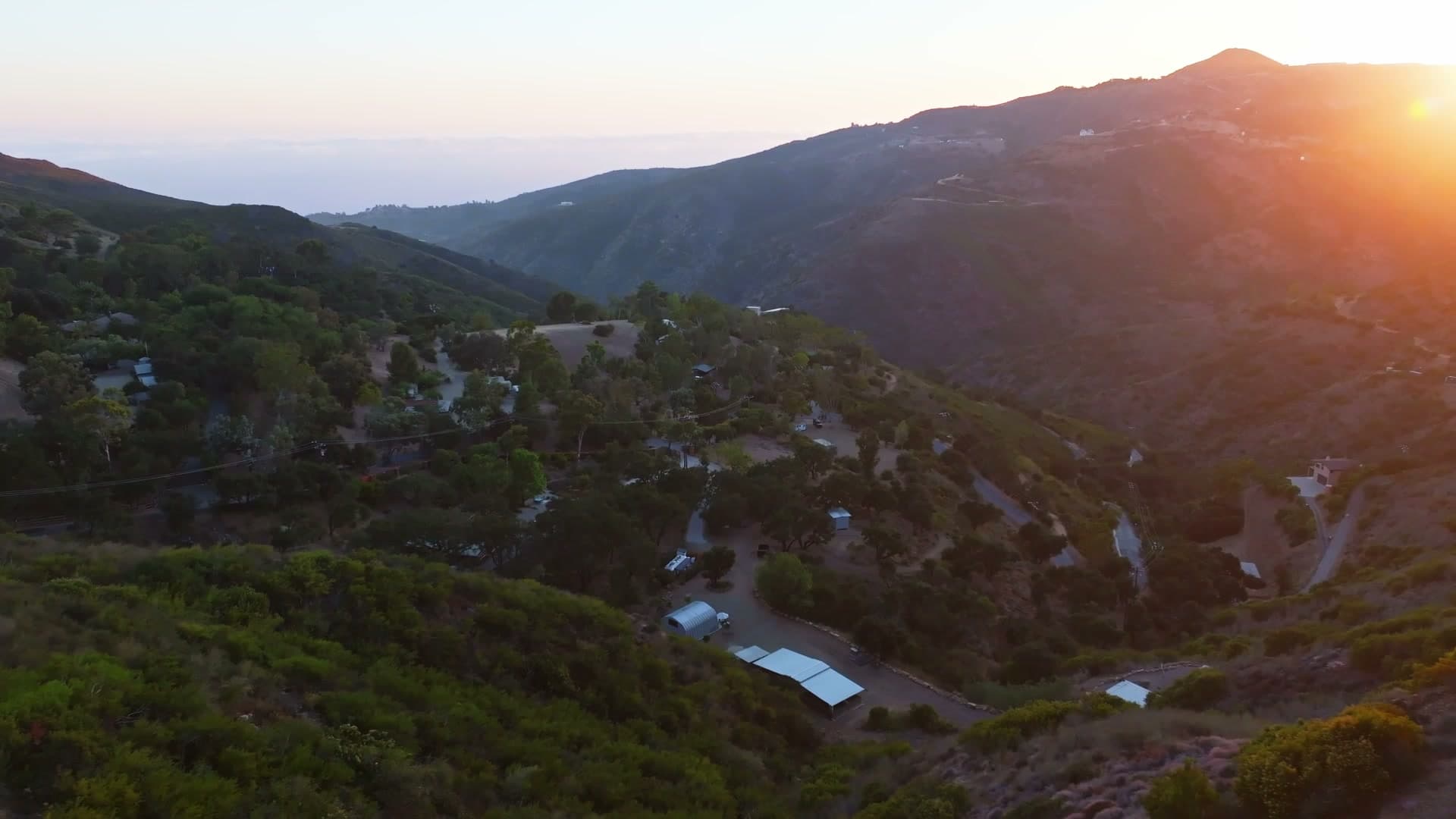 The ridge above Shakti Ranch at golden hour, with the Pacific on the horizon