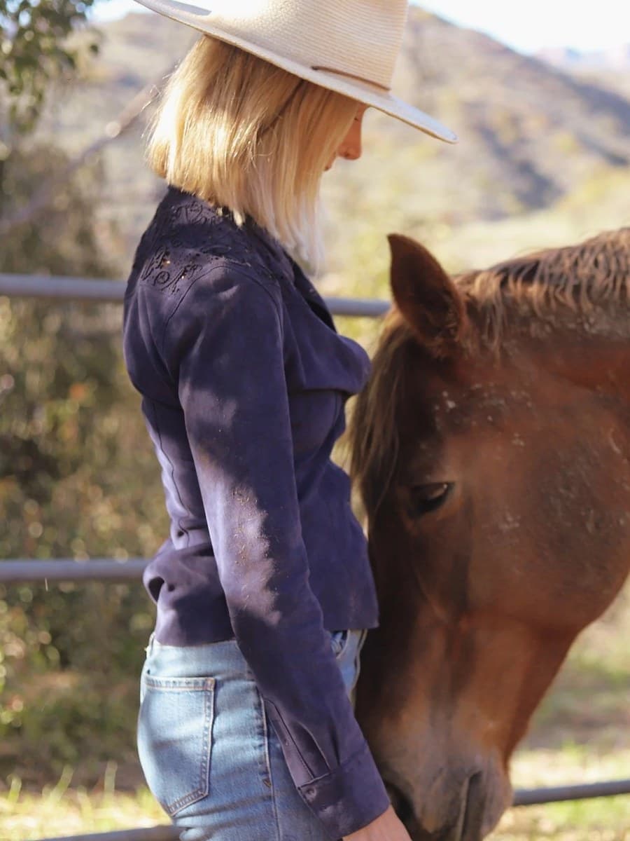 Rose Mary Riggs in a straw hat, face to face with Sophie, her chestnut mare